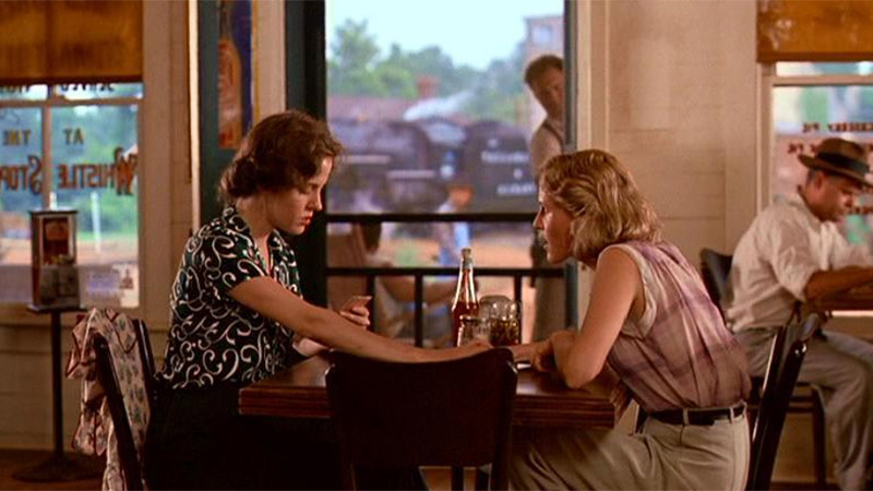 Idgie and Ruth sit at a table in a diner