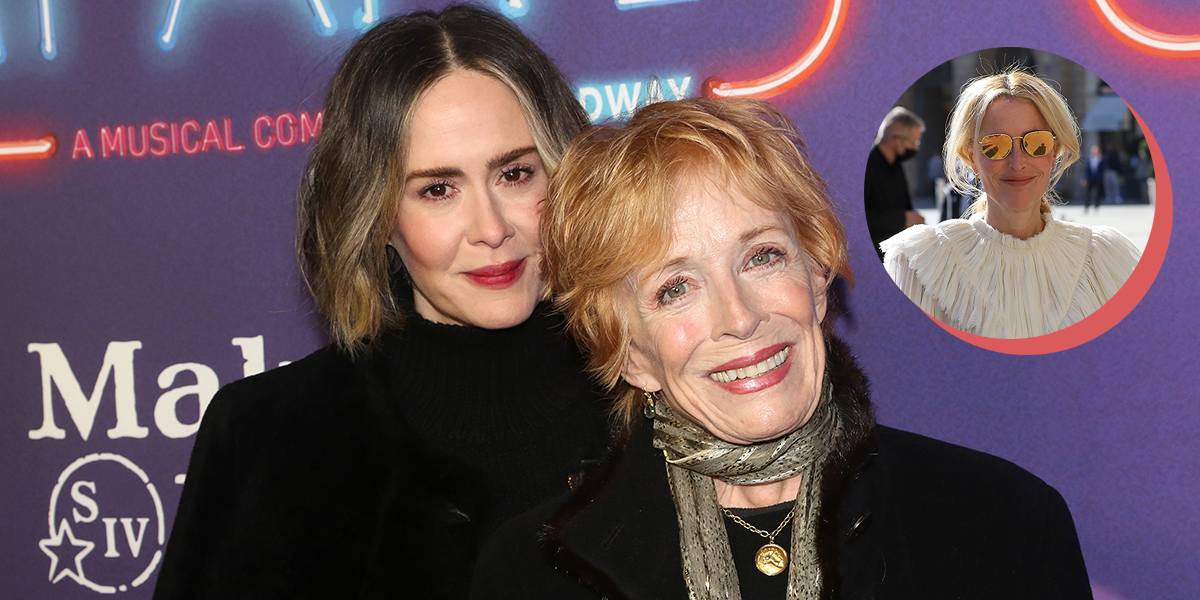 Holland Taylor and Sarah Paulson in matching black sweaters with a cut out of Gillian Anderson smiling in sunglasses