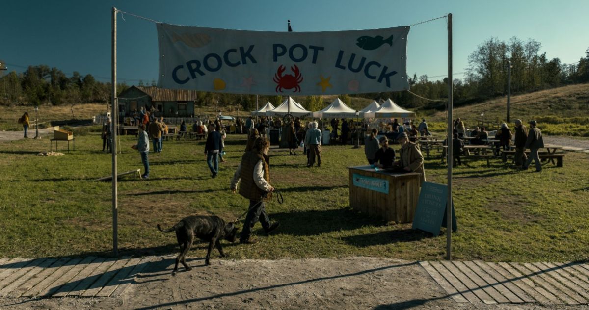 Crock Pot Luck wide view, you can see a black dog being ledin by owner, in Midnight Mass