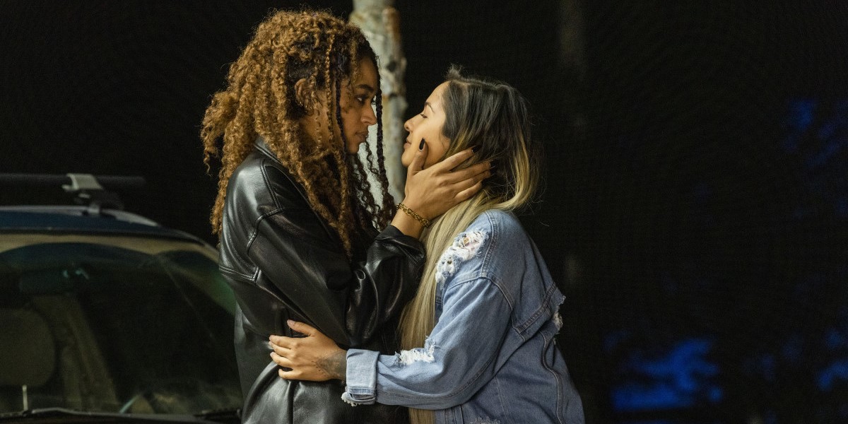Olivia and Cara from Two Sentence Horror Stories hold each other pre-kiss
