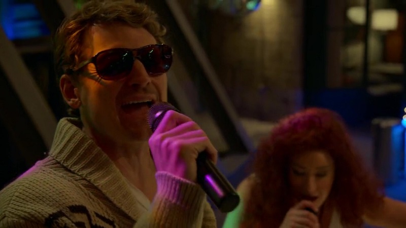 Dennis (in the foreground) and Davia (in the background) perform together during his karaoke party.