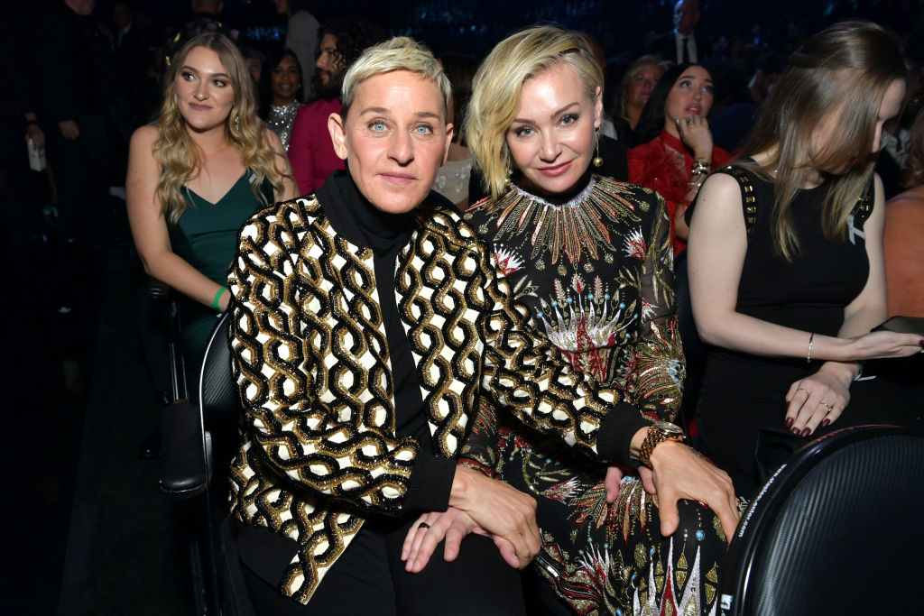 Ellen DeGeneres and Portia de Rossi attend the 62nd Annual GRAMMY Awards. Ellen is wearing a pattnered overcoat over a black top. Portia is wearing a patterned dress.