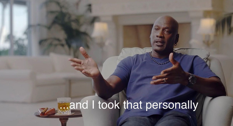 A still from The Last Dance of Michael Jordan sitting in an accent chair with outstretched arms. Across the photo are Jordan's words from the docuseries, "...and I took that personally." 