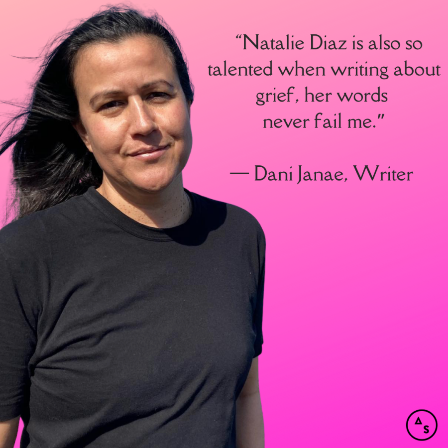 Natalie Diaz smiles at the camera with the wind in her hair, she's in front of a pink background. In front of the background is the following text: “Natalie Diaz is also so talented when writing about grief, her words never fail me.” — Dani Janae, Writer