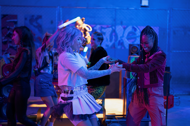 Lourdes and Naomi hold hands and dance it out at the warehouse party.