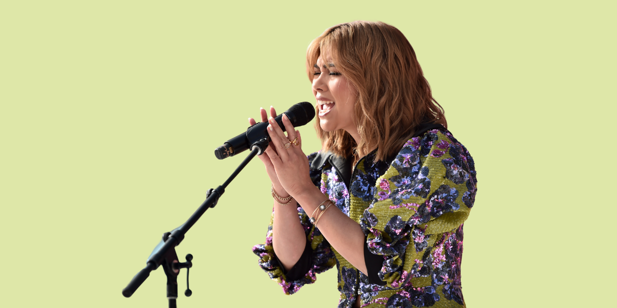 Hayley Kiyoko sings at a mic at the Teen Vogue Summit & Block Party