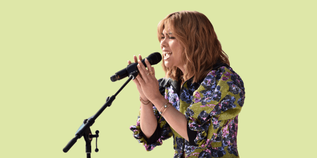 Hayley Kiyoko sings at a mic at the Teen Vogue Summit & Block Party