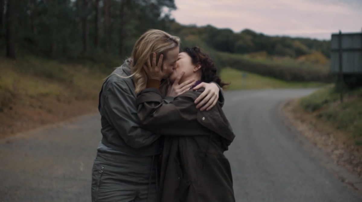 Villanelle and Eve kiss while walking along the road.