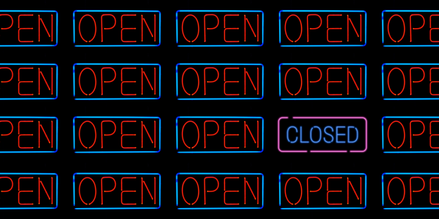 A field of neon "open" signs sits in a grid on a black background. Just one of them is replaced with a neon "closed" sign. The image is meant to evoke the sense of 'the world opening up' during the 'push to go back to normal' during the ongoing pandemic.