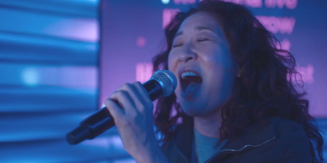 Eve Polastri (Sandra Oh) sings karaoke into a microphone on Killing Eve