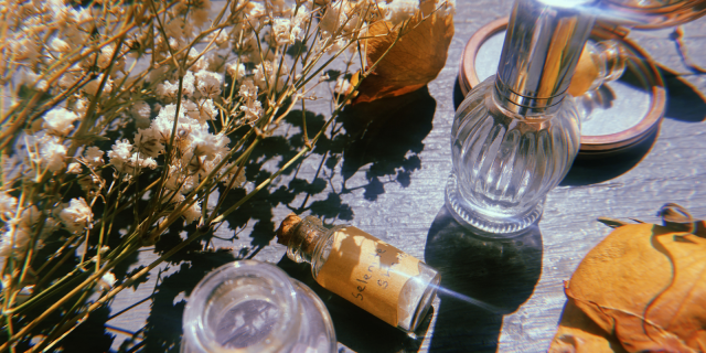 Glass bottles of crystals, spray and oils, surrounded by dried florals