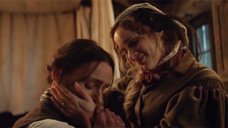 Anne Lister kneels in front of Ann Walker and kisses her hand