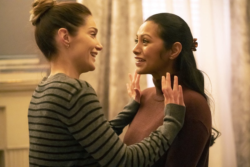 Lauren, wearing a horizontal striped sweater, tries to push Leyla away as she makes an advance.
