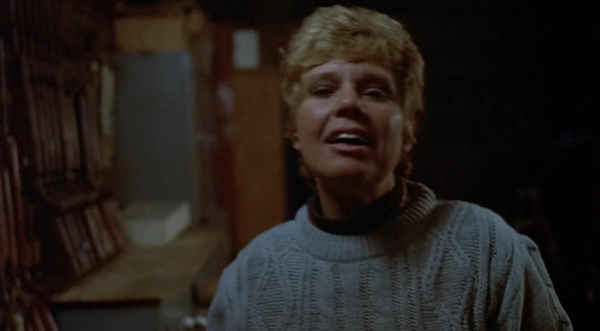Mrs. Voorhees wears her iconic blue sweater and nods her head back in Friday the 13th
