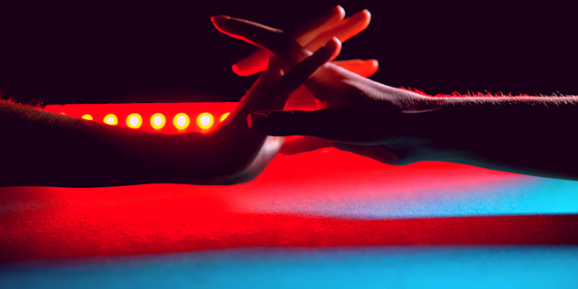 two women's hands reach for each other across a neon-lit night club background, their fingers intertwining