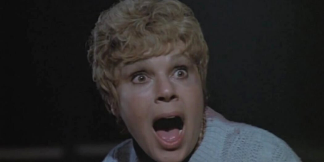 Pamela Voorhees wears her iconic blue sweater and stares with her mouth open in Friday the 13th