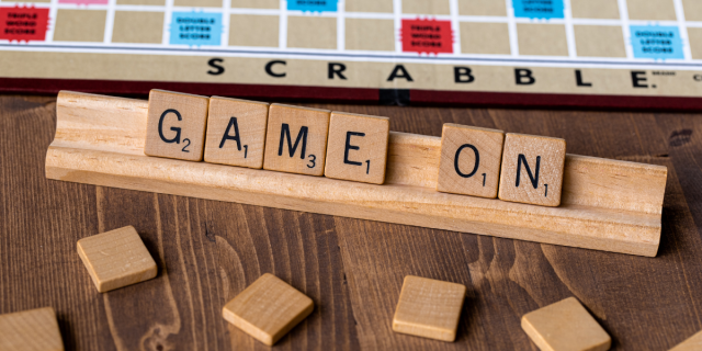 A set of Scrabble tiles spell out GAME ON