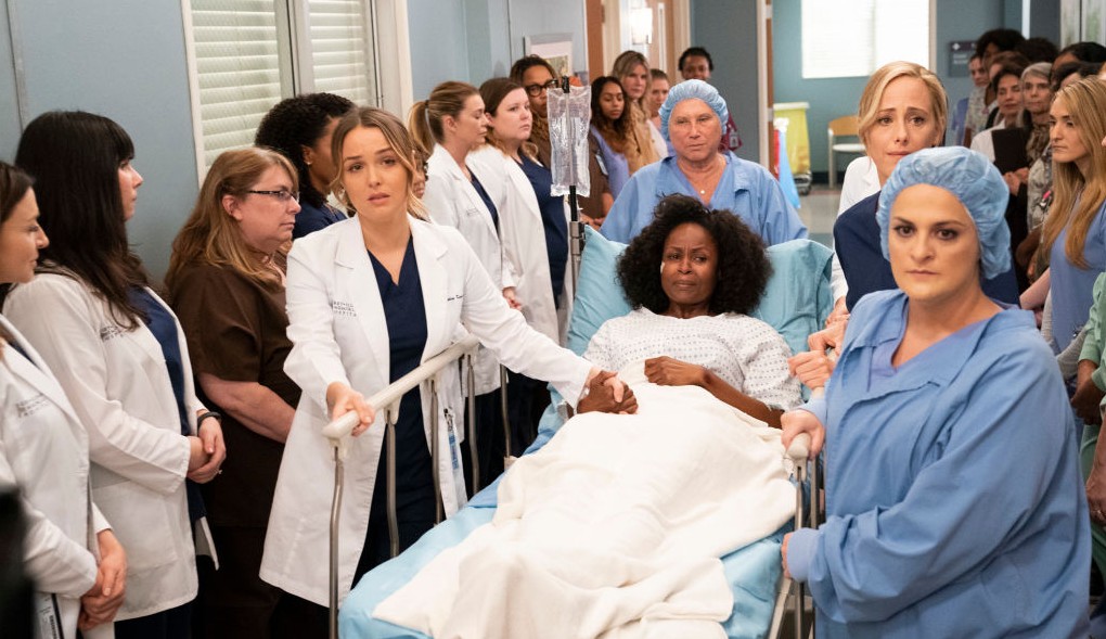 scene from Greys Anatomy of a woman in a hospital bed being rolled down the hallway