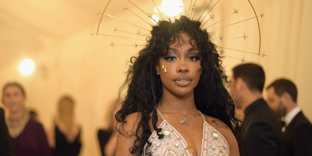 SZA, who's possibly a lesbian, at the Met Gala in a gorgeous dress with a head piece
