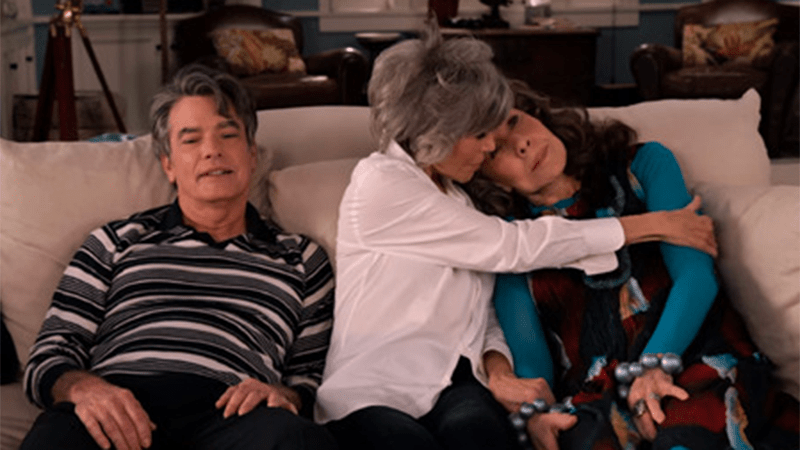 Nick sits on the couch alone while Grace hugs Frankie