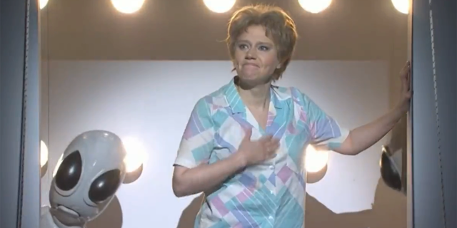 Kate McKinnon holds her hand over her heart in her final alien abduction sketch on SNL