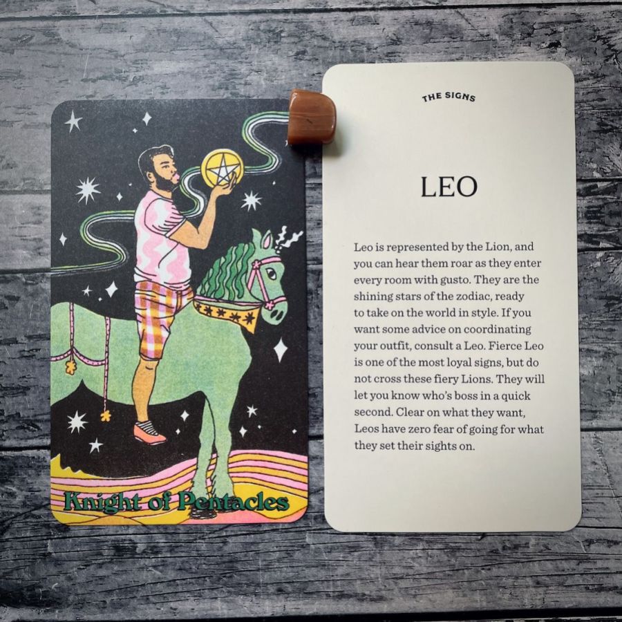 In two tarot cards on a grey background:  Left: A man with light brown skin tone and a beard rides a green unicorn in front of a starry night sky, he is holding a gold pentacle in his hands and appears to make a kissy face towards it. Right: Leo