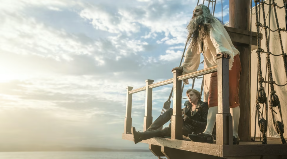 Blackbeard and Stede stand in the crow's nest of the ship and look at out at the ocean
