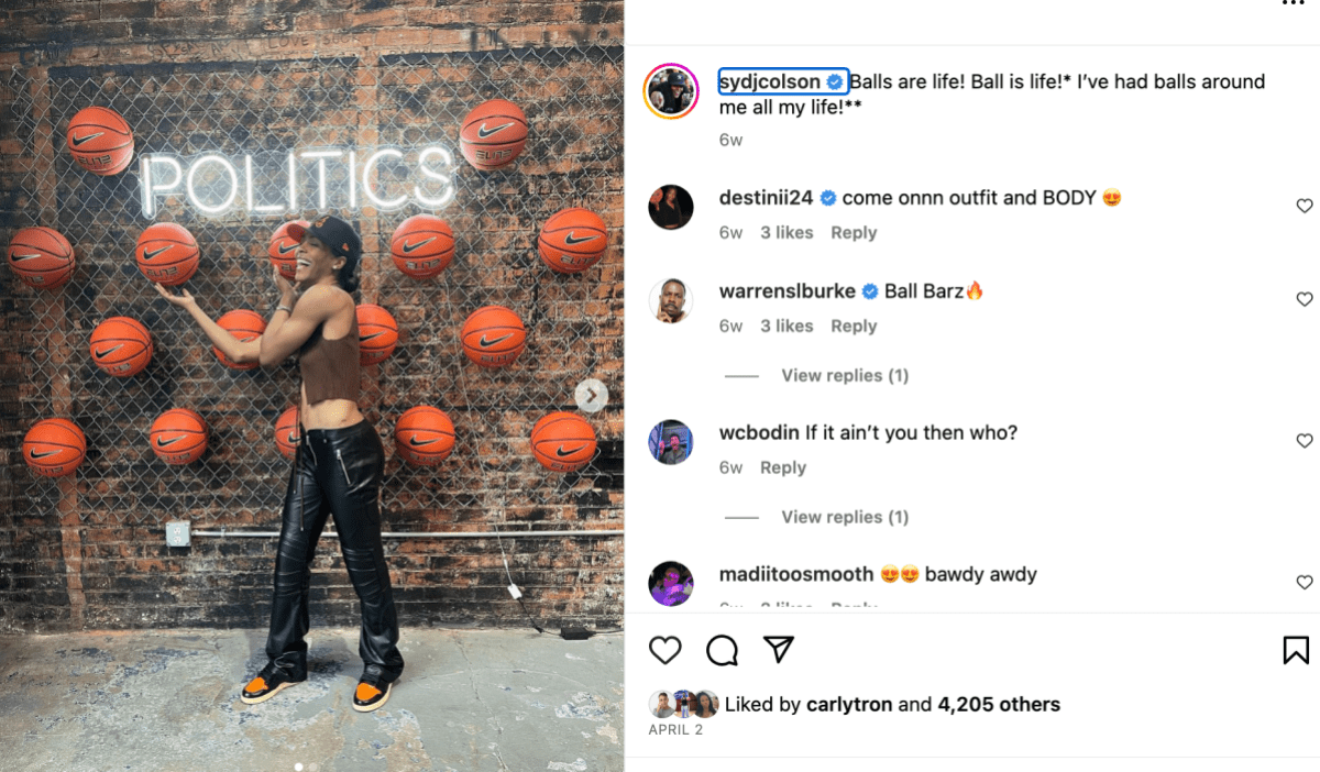 A screenshot of Syd Colson's Instagram. She's wearing leather pants and tank top, standing in front of a wall of basketballs. A neon sign on the wall says POLITICS. 
