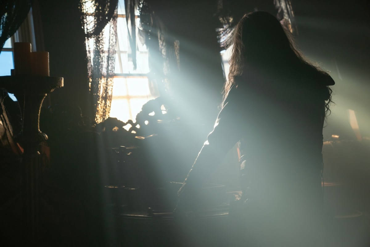 A pirate stands facing an open window as the morning sun shines through