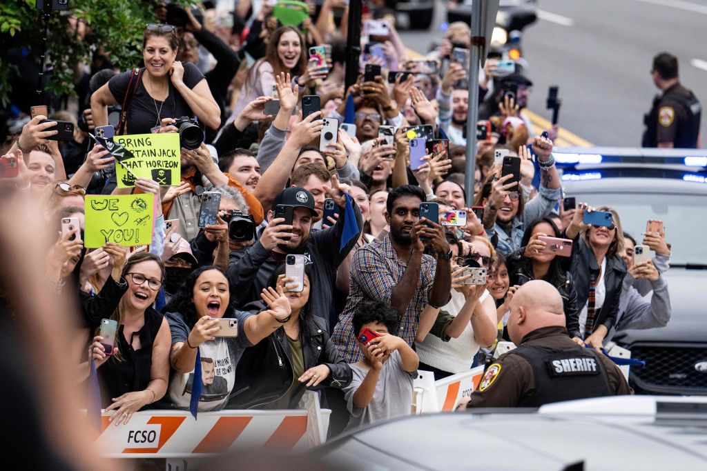 Fans cheer as actor Johnny Depp arrives for closing arguments in the Depp v. Heard trial at the Fairfax County Circuit Courthouse in Fairfax, Virginia, on May 27, 2022. - Actor Johnny Depp is suing ex-wife Amber Heard for libel after she wrote an op-ed piece in The Washington Post in 2018 referring to herself as a public figure representing domestic abuse. (Photo by Jim WATSON / AFP) (Photo by JIM WATSON/AFP via Getty Images)