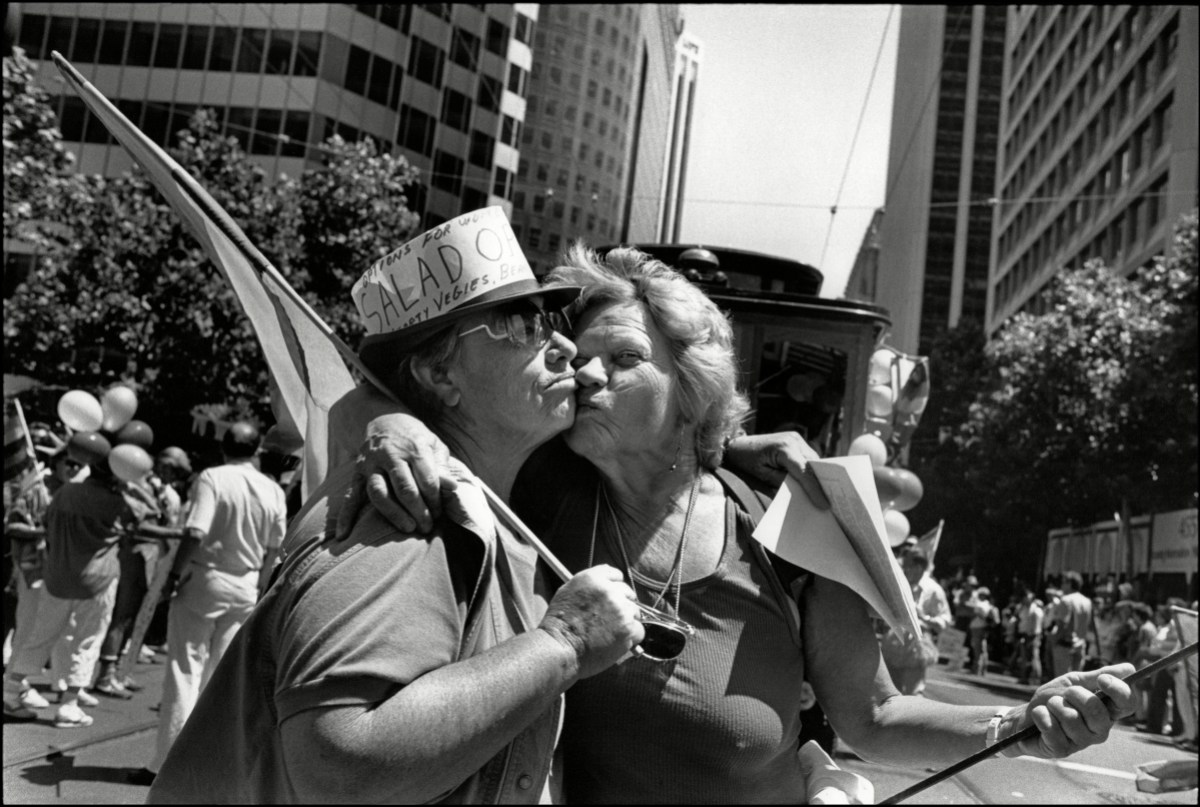 View of two elderly women as they kiss on Market Street 