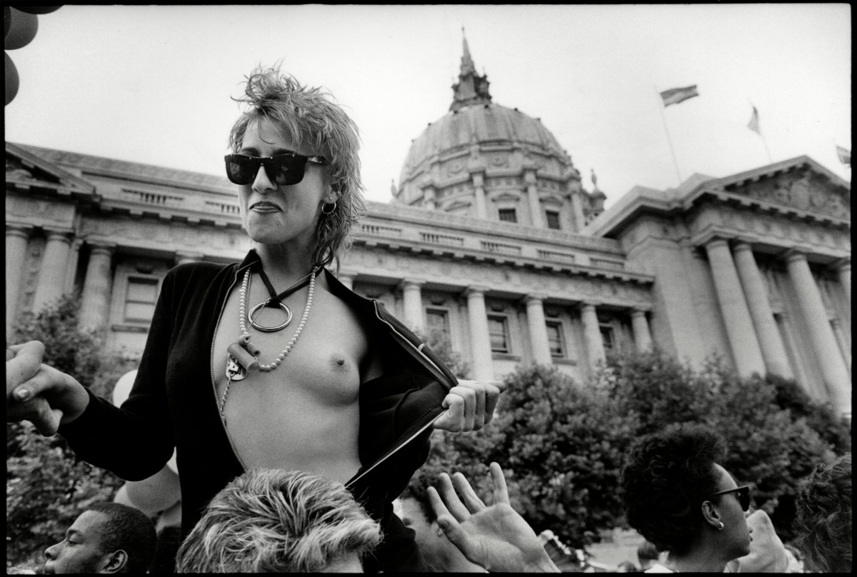 View of a bare-breasted marcher at Pride in a leather jacket