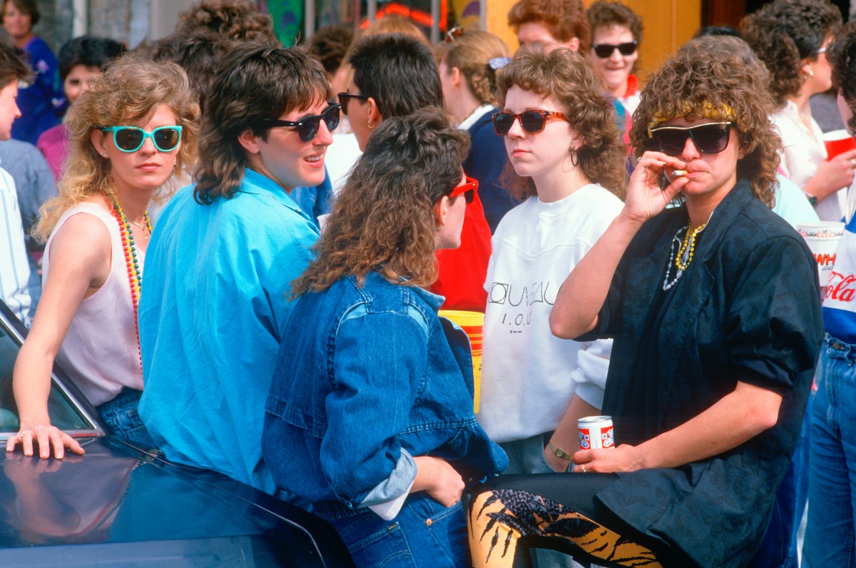 Lesbian women congregate in New Orleans, LA, the photo is in full color and they have brightly colored sunglasses and t-shirts