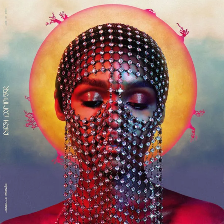 dirty computer album cover where janelle monae has a veil of beads over her face her eyes are cloed and a painted sun is against her head like a halo