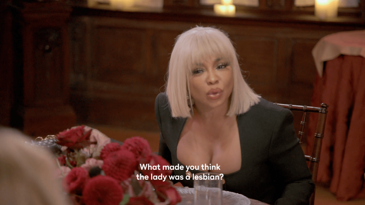Phaedra Parks, a Black woman wearing a platinum blonde bobbed wig with gangs and a black dress, says "What made you think the lady was a lesbian?" on Ultimate Girls Trip