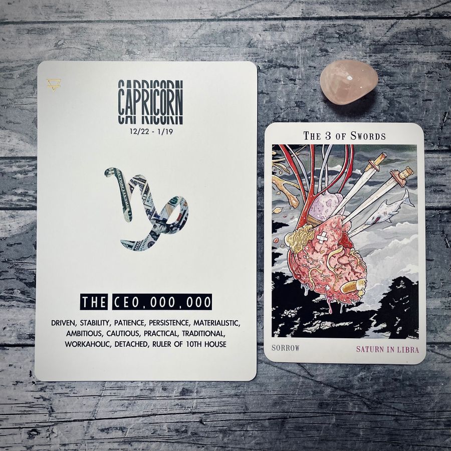  Left Card: Capricorn, the CEO, DRIVEN, STABILITY, PATIENCE, PERSISTENCE, MATERIALISTIC, AMBITIOUS, CAUTIOUS, PRACTICAL, TRADITIONAL, WORKAHOLIC, DETACHED, RULER OF 10TH HOUSE  Right Card: The 3 of swords is a drawing of a bruised and beaten heart with band aids and three swords sticking out, on top of one of the sword is a shark  Underneath it says: sorrow, Saturn in libra