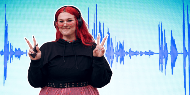 A person with long red hair wearing a black shirt and semi translucent skirt, holds their fingers up in two peace signs. they have long nails, are wearing rose tinted glasses, have a septum piercing, and are wearing black headphones. The background looks like a soundwave.