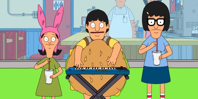 In a still from Bob's Burgers, Bob's three children are standing outside their father's burger joint. Left to right, there is Louise in a pink hat with bunny ears, then Gene in a burger suit playing piano, and Tina with a blue shirt and navy blue skirt, glasses, drinking a milkshake.