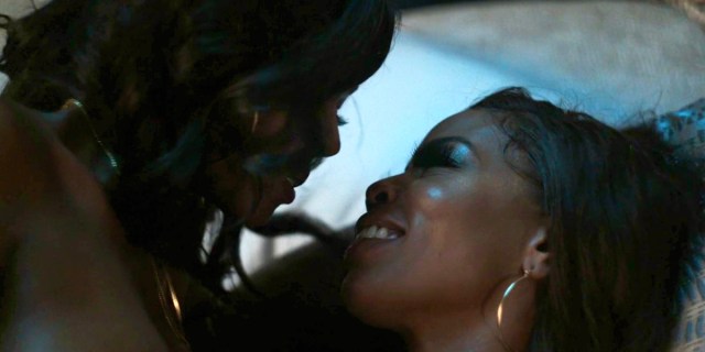 P-Valley 206 Recap: Mercedes and Farrah share an intimate moment in bed, smiling.