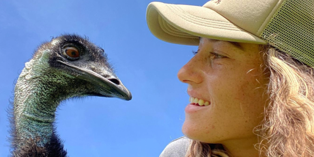 Emmanuel the emu and his caretaker stare at each other and smile