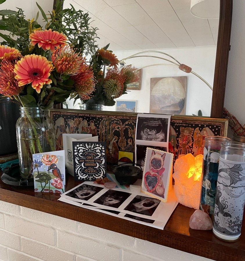 Photos of the ultrasound surrounded by flowers, candles and gifts