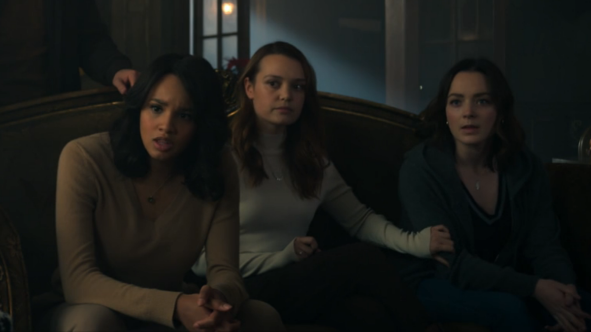 Abigail, Tally, and Scylla sit on the couch and look pissed; Tally has a hand on Scylla's arm