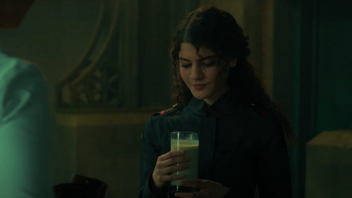 Penelope grins weirdly at her glass of milk