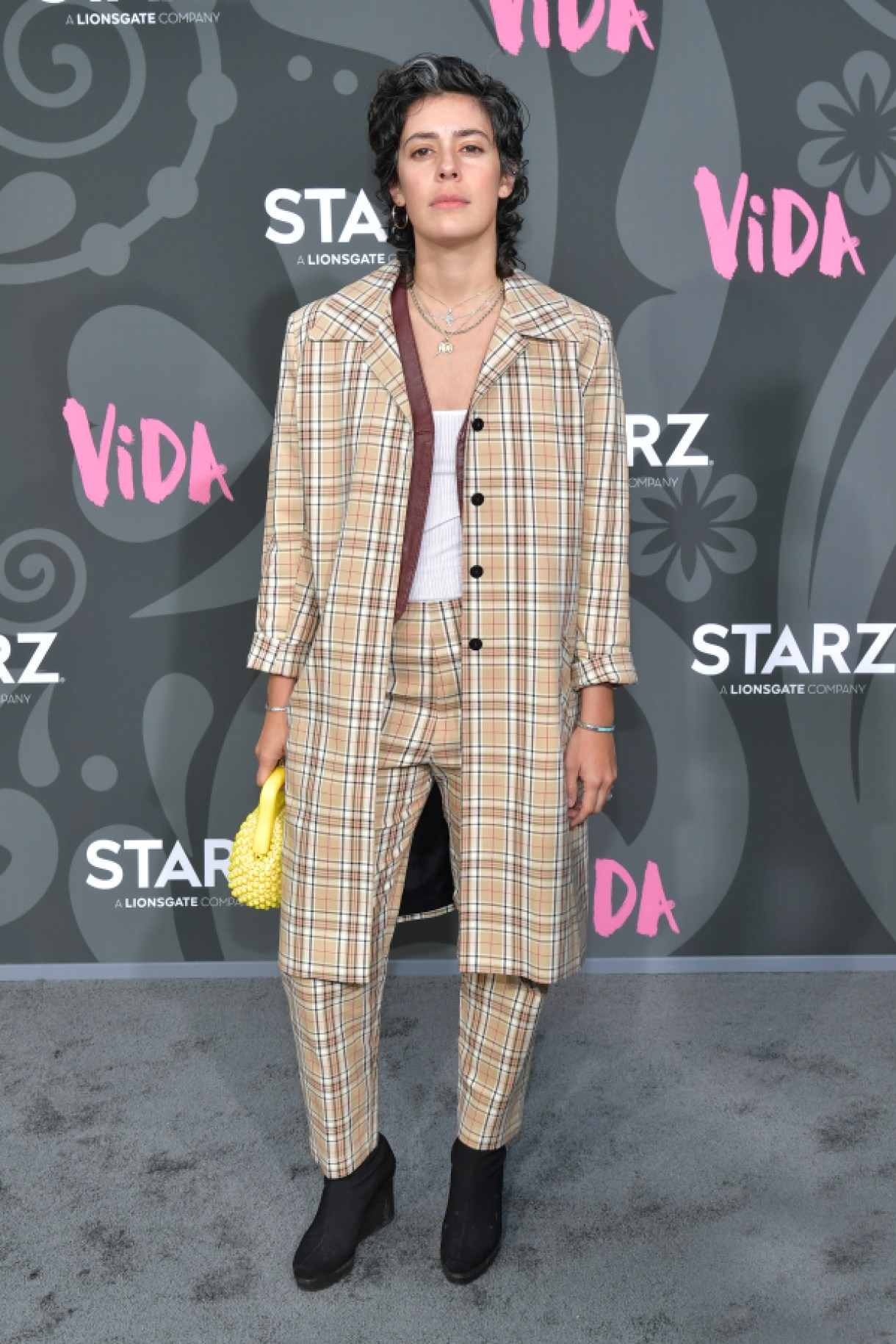 Roberta Colindrez in a yellow and brown plaid suit attends LA Premiere Of Starz' "VIDA" at Regal Downtown Theater on May 20, 2019 in Los Angeles, California. (Photo by Amy Sussman/Getty Images)