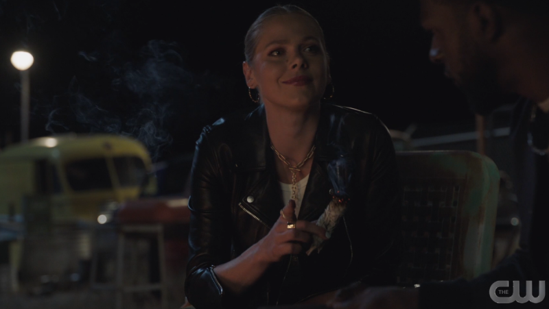 Isobel wears a leather jacket and holds sage 