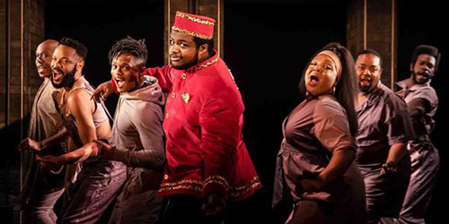 A still from Strange Loop on Broadway has the lead usher character in a red suit dancing with the cast