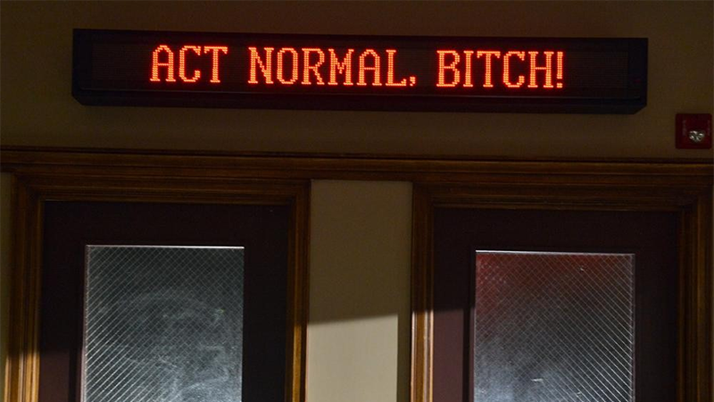 A sign that says "ACT NORMAL, BITCH"