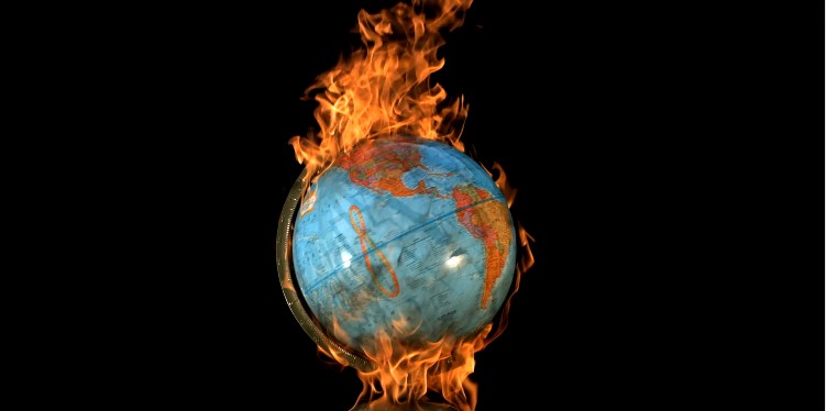 a globe of the earth is set afire against a black backdrop in this featue image