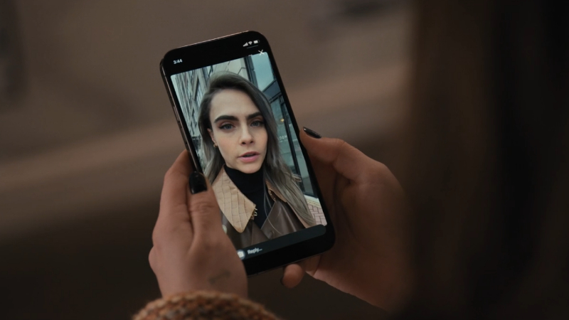 Shot of a phone with Cara Delevingne's face on it 