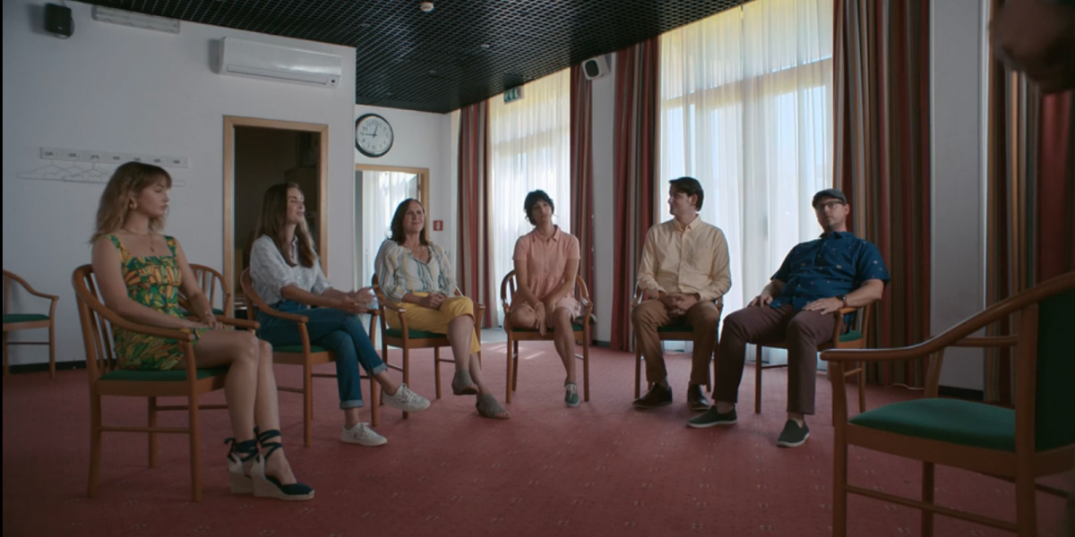 A group of people in a room but one is wearing wedges